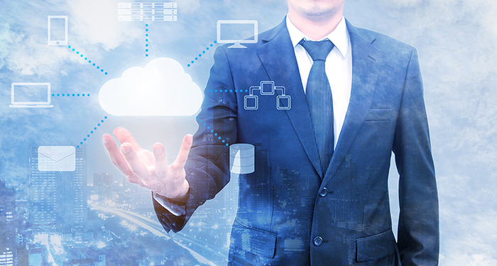 Person in a suit with their palm facing up underneath an illustrated cloud with various computer themed icons connected to it with lines.